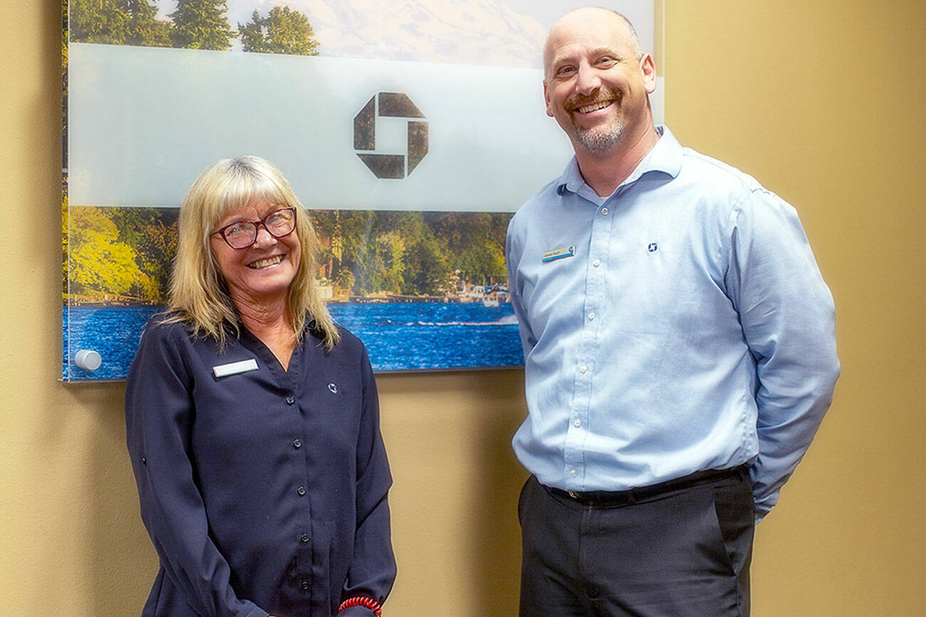 Elva Hulett, left, and James Hoch, Port Angeles' Chase Bank branch manager, right, smiling together, reminiscing Elva's milestone achievement at Chase Bank on August 8, 2024. (Christopher Urquia/Peninsula Daily News)