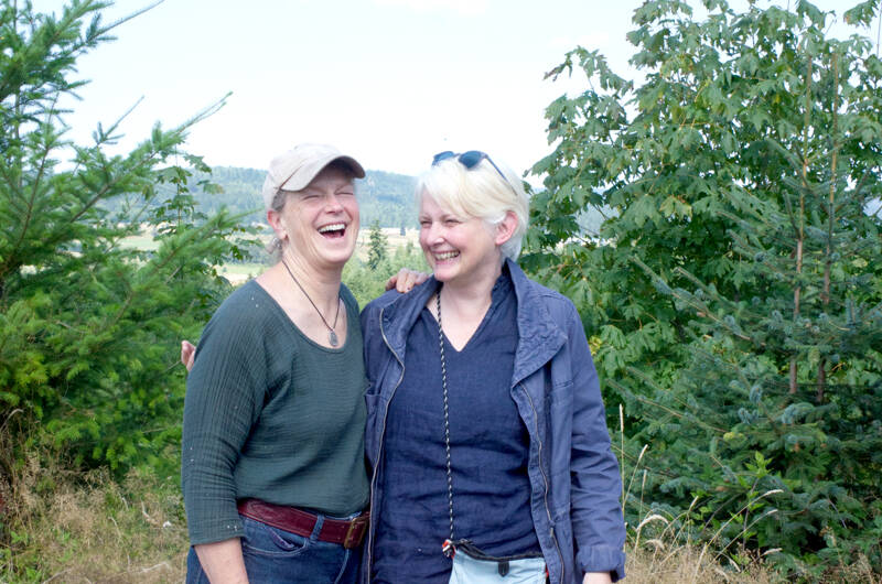 Sarah Spaeth, left, and Kate Godman stand at a viewpoint on the north side of the newly acquired Chimacum Ridge Community Forest. (Elijah Sussman/Peninsula Daily News)