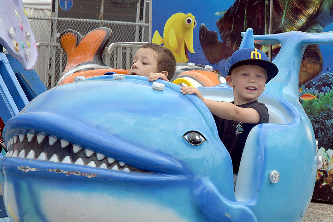 Cevoun Anders, 5, of Port Angeles, left, and Brixton Dennis, 3, of Sequim take a ride on the Flying Fish amusement ride at the Clallam County Fair on Saturday in Port Angeles. (Keith Thorpe/Peninsula Daily News)