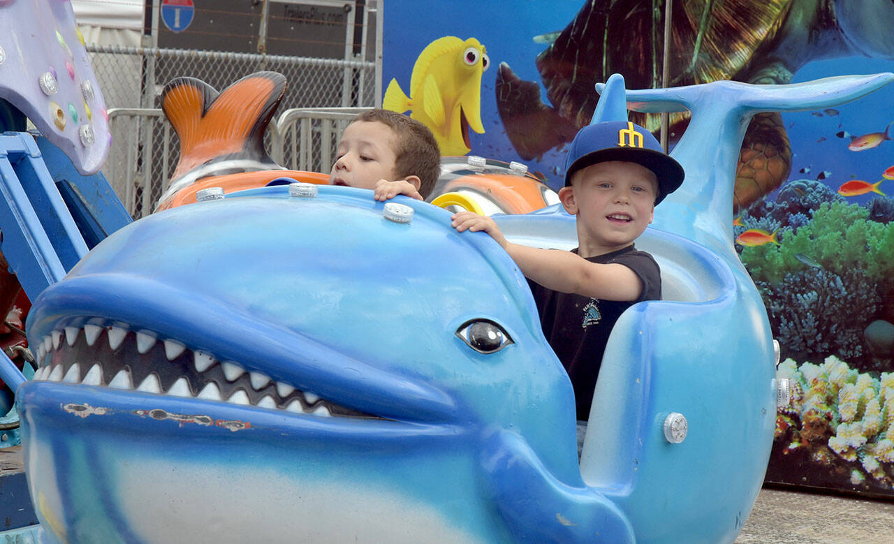 Cevoun Anders, 5, of Port Angeles, left, and Brixton Dennis, 3, of Sequim take a ride on the Flying Fish amusement ride at the Clallam County Fair on Saturday in Port Angeles. (Keith Thorpe/Peninsula Daily News)