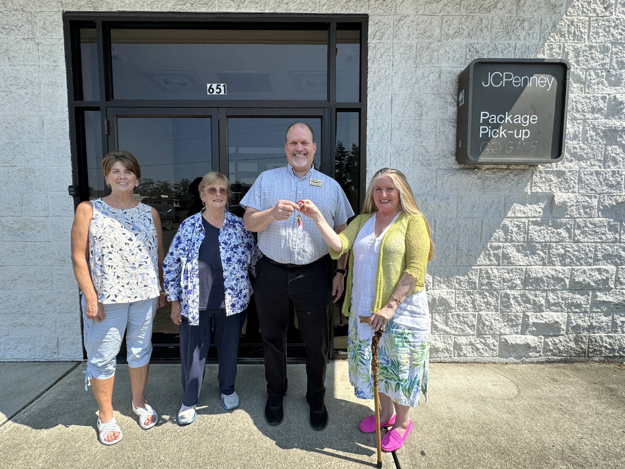 Eileen Schmitz, JACE Real Estate owner and Shipley Center board member, presents the keys of the former JCPenney building at 651 W. Washington St. to Shipley Center executive director Michael Smith following the center’s Aug. 8 purchase of the building. At far left is Joyce Gladen of JACE Real Estate, and second from left is Shipley Center board secretary Margaret Cox. (Shipley Center)