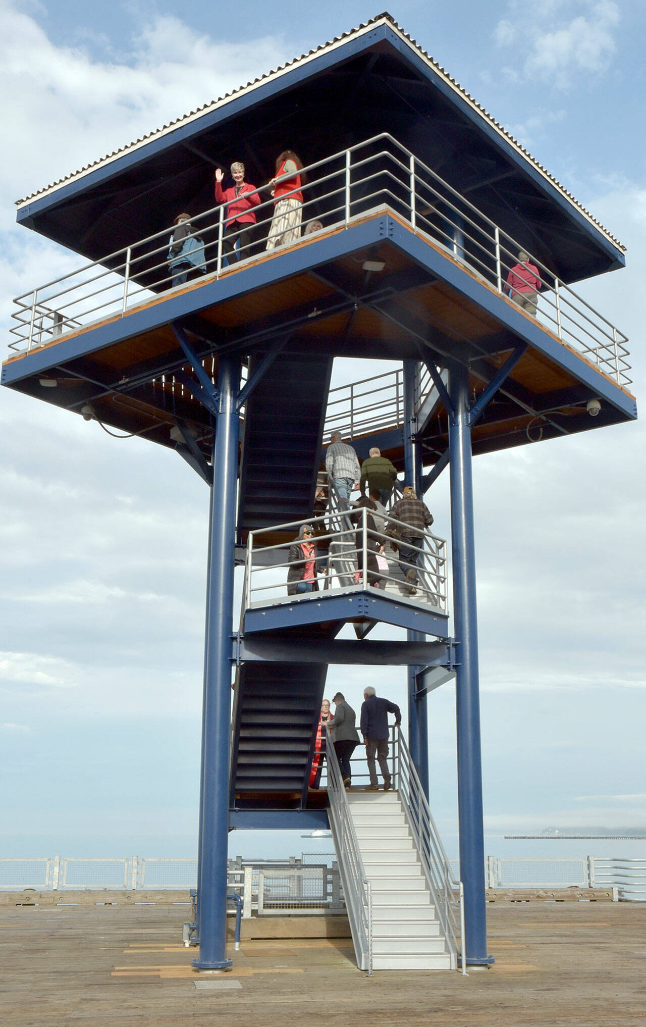 Visitors and dignitaries ascend the steps at the observation tower at Port Angeles City Pier on Wednesday after a ceremony to officially reopen the structure to the public. The tower was closed in November 2023 due to safety issues and structural concerns, prompting numerous repairs. Funding for the work, totaling more than $650,000, came from city lodging tax. (Keith Thorpe/Peninsula Daily News)