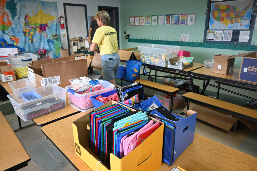 Kim Rosales and other volunteers help gather school supplies for students at last year’s Back to School Fair at the Sequim Boys & Girls Club. (Michael Dashiell/Olympic Peninsula News Group)