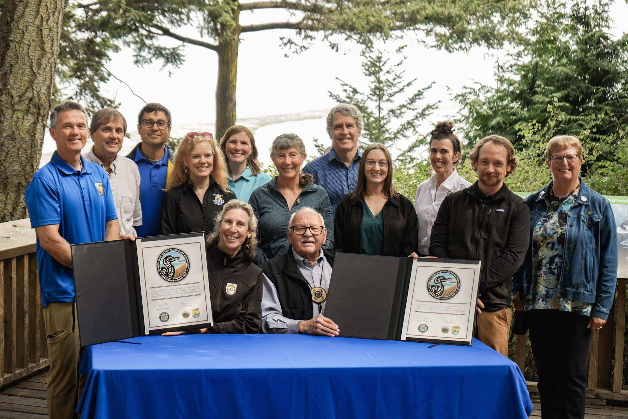 Martha Williams, director of the U.S. Fish & Wildlife Service, and Ron Allen, CEO and chairman of the Jamestown S’Klallam Tribe (both seated), celebrate the signing of a co-stewardship agreement for the Dungeness and Protection Island National Wildlife Refuges on Aug. 16. (Jamestown S’Klallam Tribe)