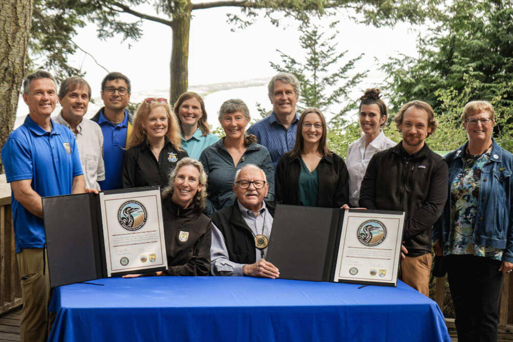 Martha Williams, director of the U.S. Fish & Wildlife Service, and Ron Allen, CEO and chairman of the Jamestown S’Klallam Tribe (both seated), celebrate the signing of a co-stewardship agreement for the Dungeness and Protection Island National Wildlife Refuges on Aug. 16. (Jamestown S’Klallam Tribe)