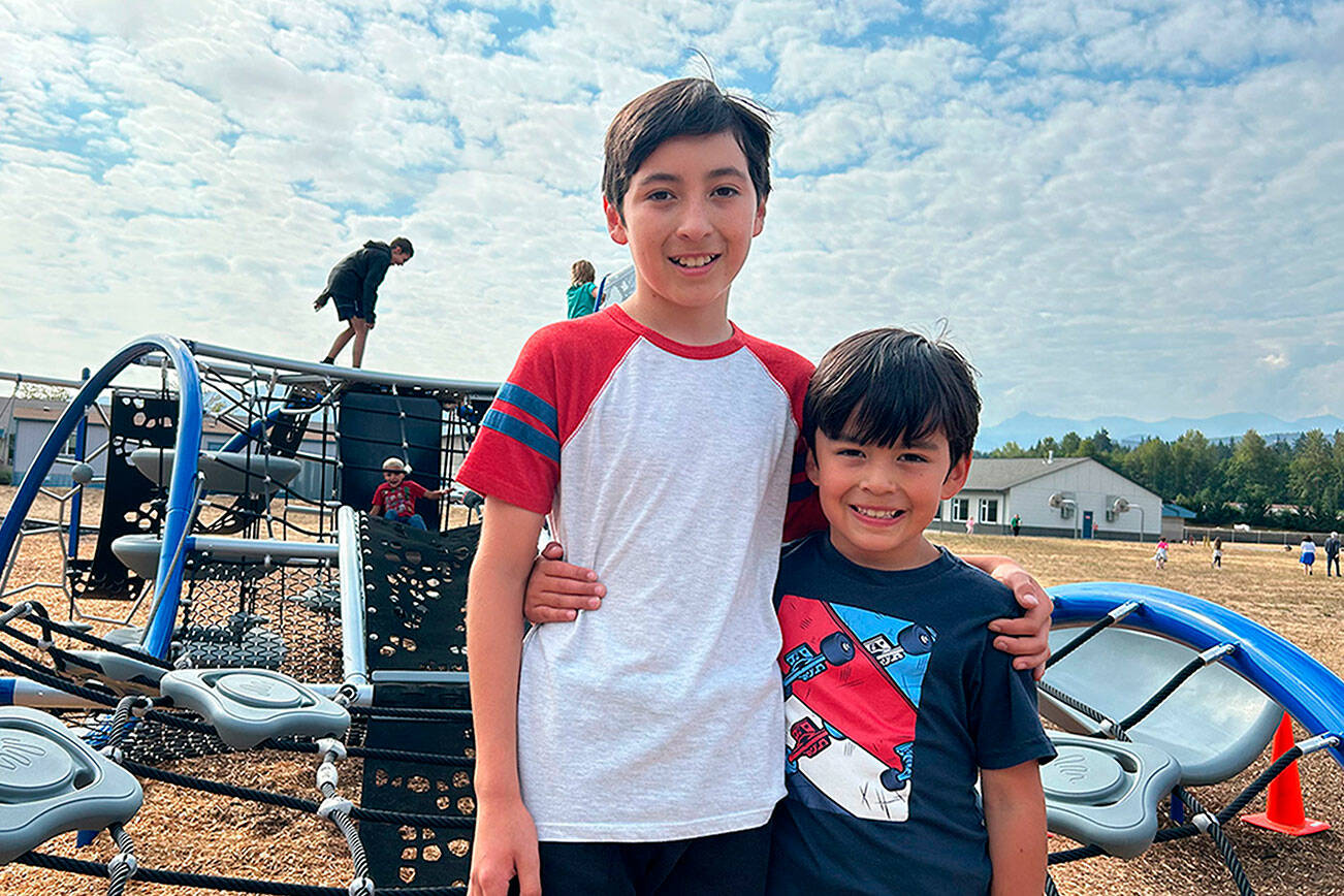 Ocean Mounts, 12, stands with his brother Ollie, 7, on Greywolf Elementary School’s new playground Quantis M2. Ocean suggested a new playground a few years ago, and Sequim School District and PTA leaders have sought funds for the project. He now attends Sequim Middle School and said he’s glad his brother and other children will get to play on the structure. (Matthew Nash/Olympic Peninsula News Group)