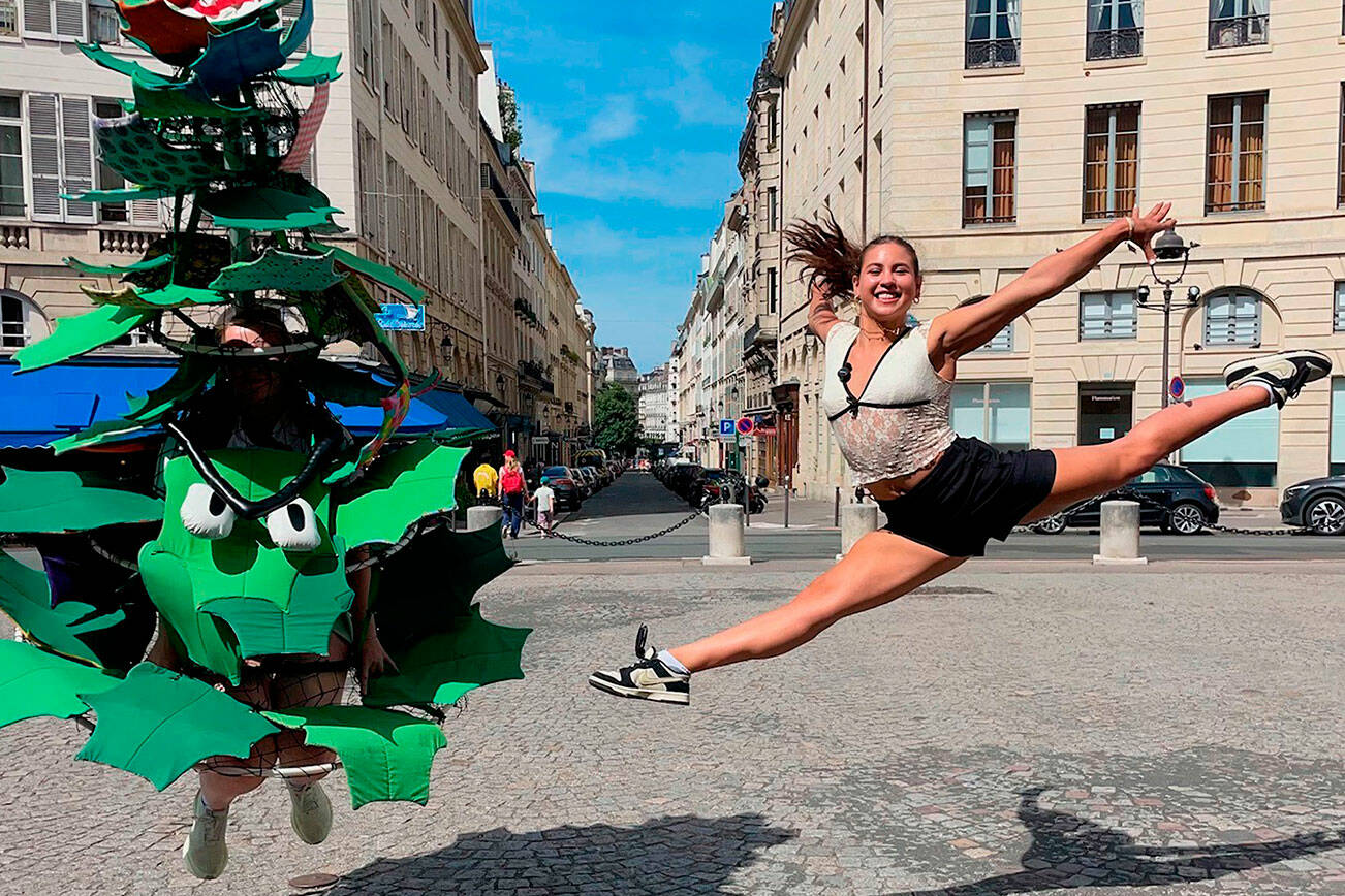 Ruby Coulson of Sequim, playing as the Stanford Tree, and gymnast Levi Jung-Ruivivar, who competed for the Philippines’ women’s gymnastics team and is an incoming Stanford freshman, jump together in Paris during an interview promoting the university’s many Olympians. (Stanford Athletics)