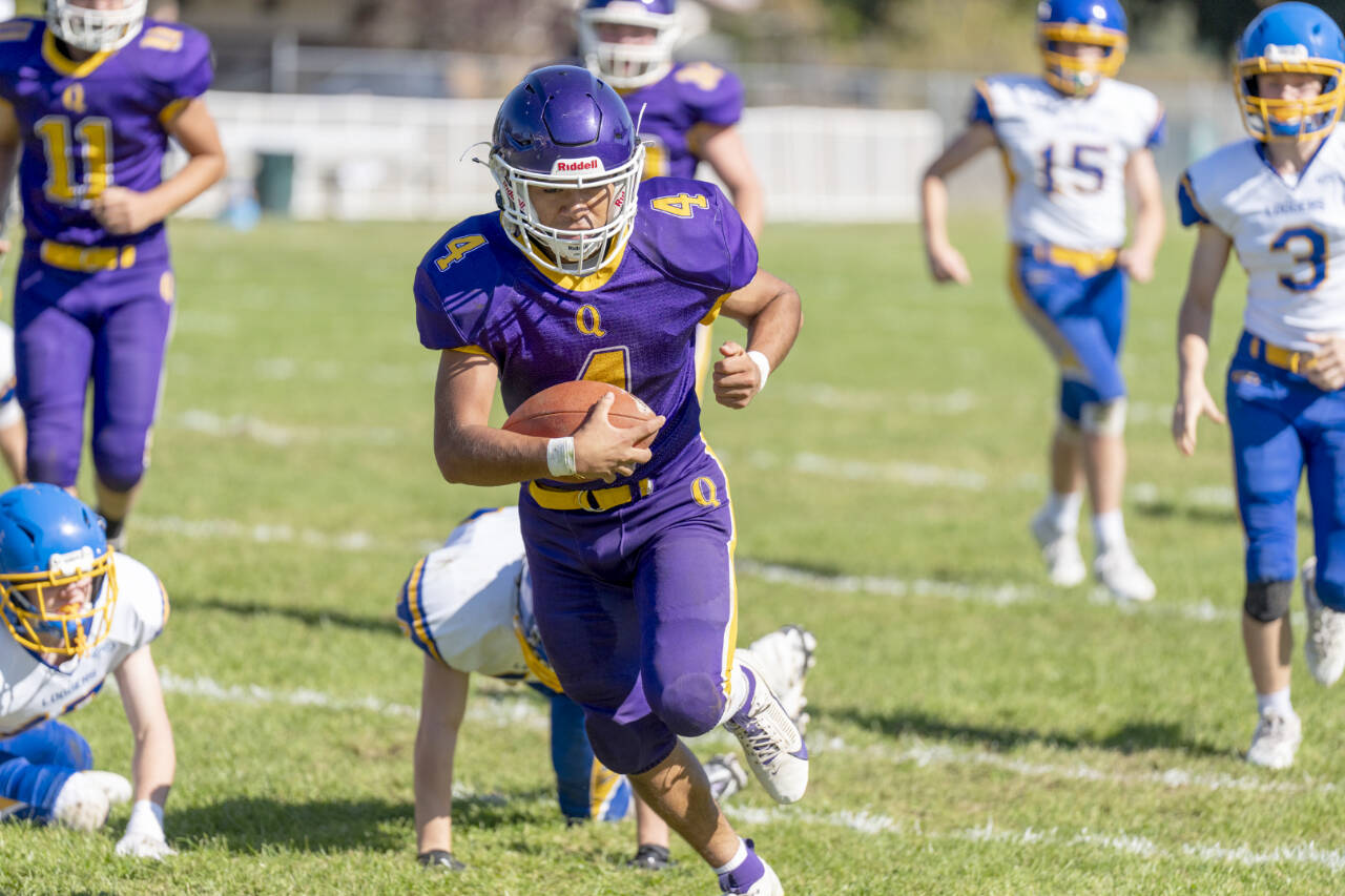 Quilcene's Andrew Perez runs for yardage against Crescent on Saturday in Quilcene. In on the play are Crescent's Conner Bauers (3) and Henry Bourm (15). Steve Mullensky/for Peninsula Daily News