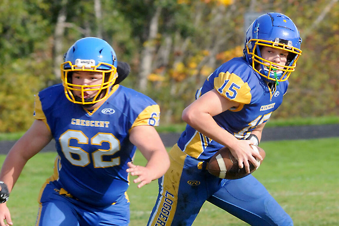 KEITH THORPE/PENINSULA DAILY NEWS
Crescent quarterback Henry Bourm, right, looks to pass while teammate Thomas Leonard fends off the Concrete defense on Saturday in Joyce.