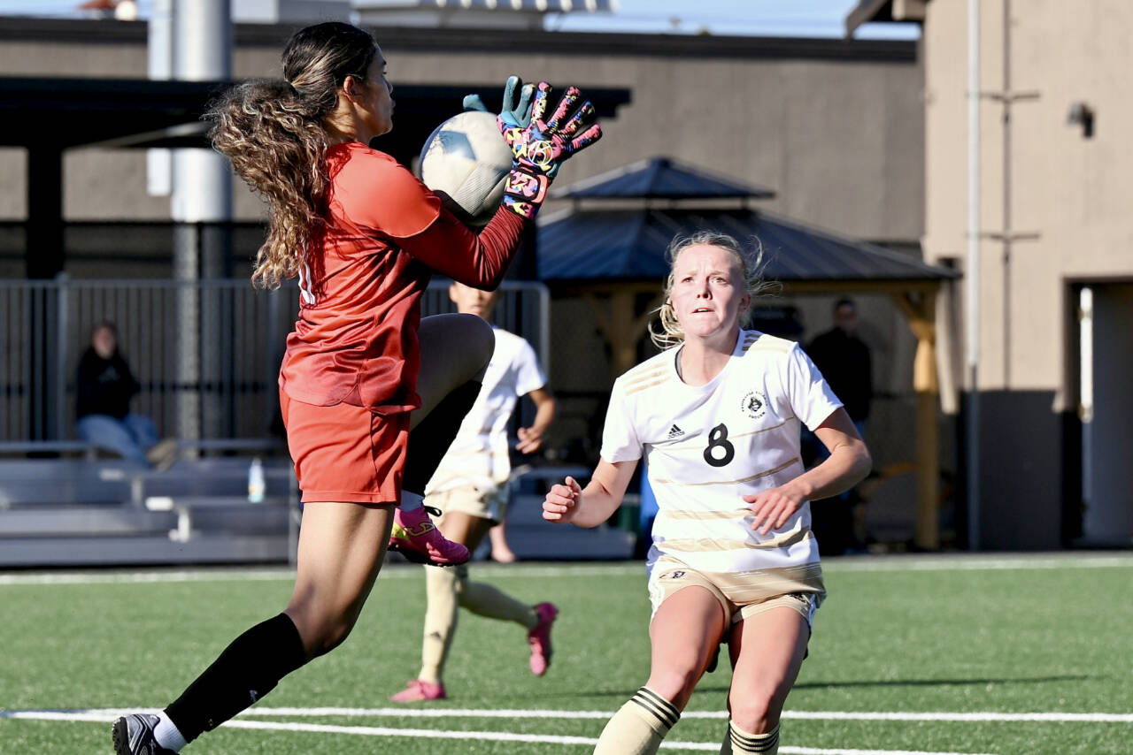 Peninsula College's Anna Petty battles Multnomah University goalkeeper Jennifer Alvilar for control of the ball during Tuesday's scrimmage at Walla Sigmar field in Port Angeles. (Jay Cline)