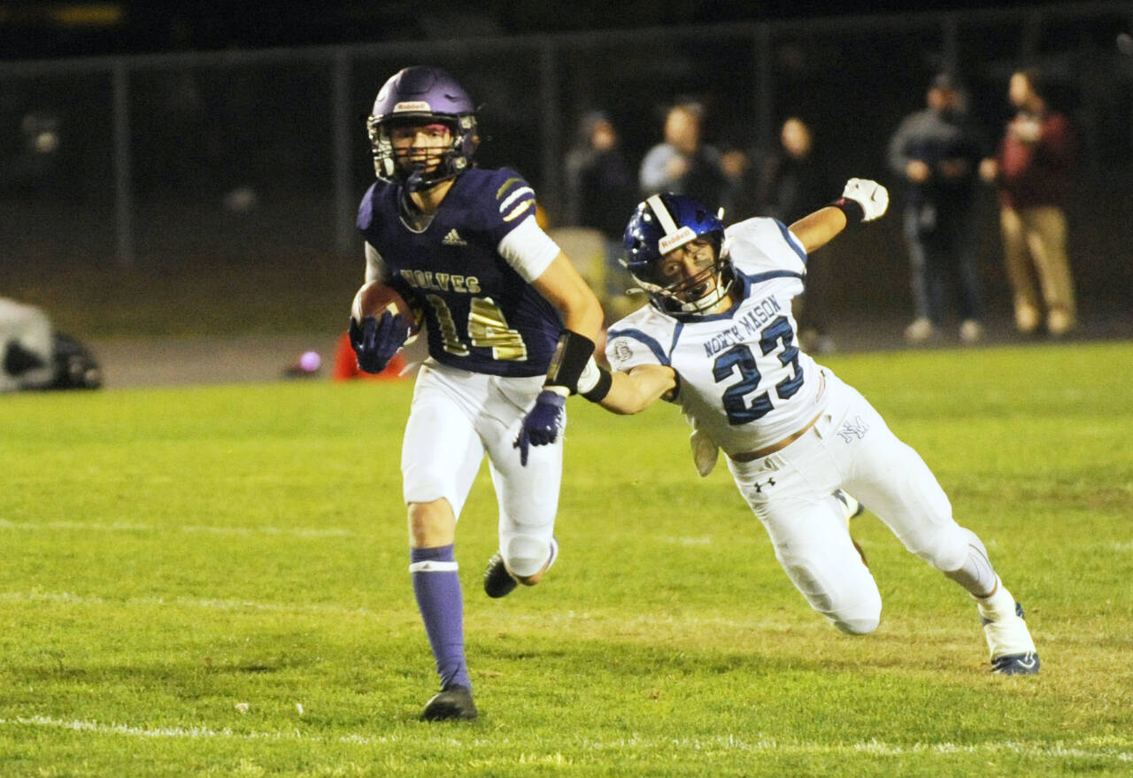 Sequim Gazette photo by Michael Dashiell Sequim’s Zeke Schmadeke, left, races away from North Mason defender Caden Atencio in the Wolves’ 36-0 Homecoming victory on Oct. 13.