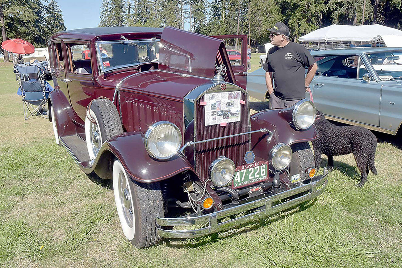 John Anderson of San Juan Capistrano, Calif., and his dog, Myla, examine a 1929 Pierce Arrow Model 133 on display at the Kiwanis Club of Port Angeles Car Show on Saturday at the Clallam County Fairgrounds. Dozens of classic and vintage automobiles were on display in an event to benefit Kiwanis community programs. (Keith Thorpe/Peninsula Daily News)