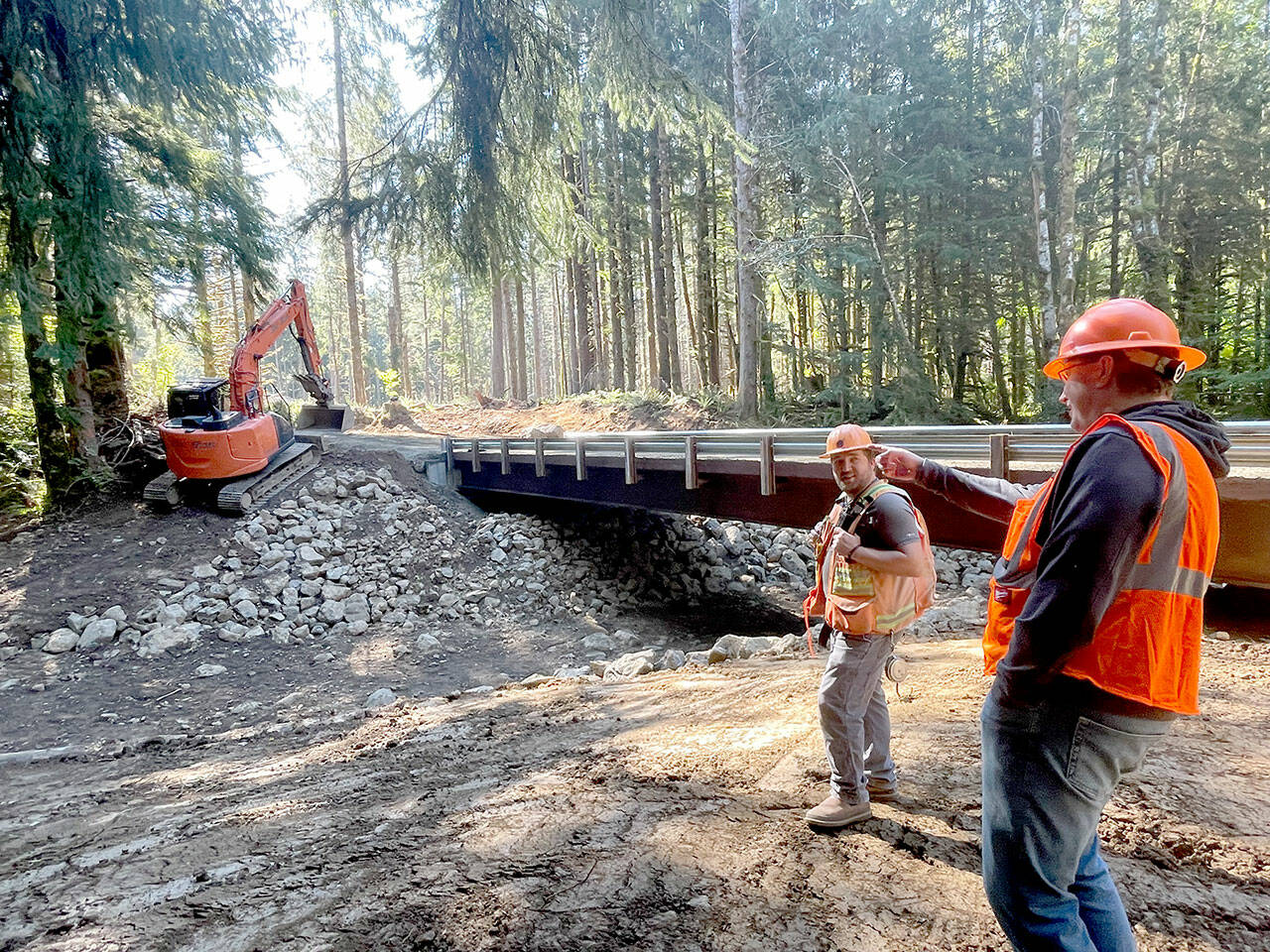 Scott Hanna, right, and Chad Vandehey, engineers with the state Department of Natural Resources’ Olympic National Forest unit, check out a new bridge over a tributary to the Calawah River. The project is a Good Neighbor Authority partnership between DNR and the U.S. Forest Service. (Paula Hunt/Peninsula Daily News)