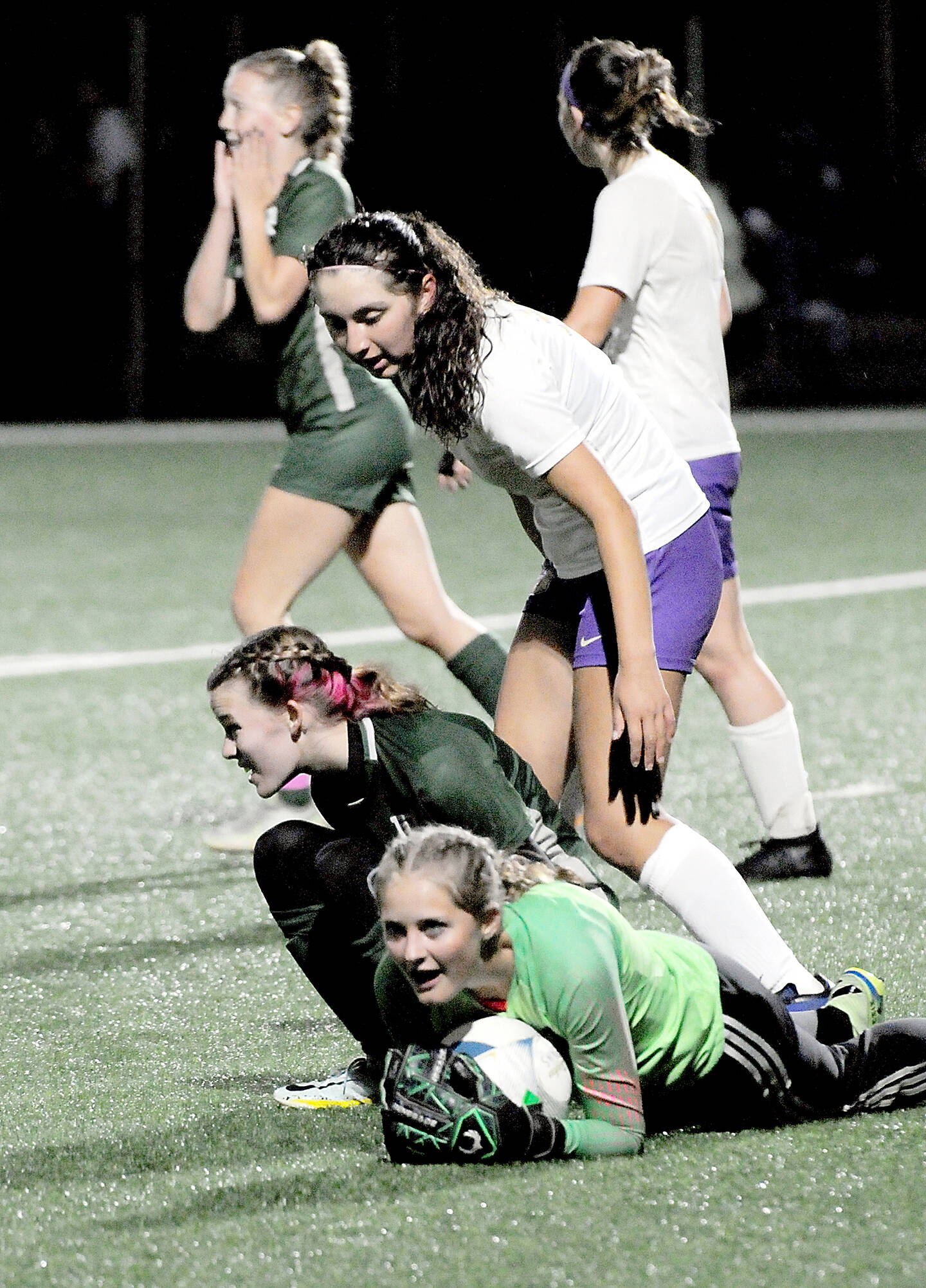 KEITH THORPE/PENINSULA DAILY NEWS 
Sequim goalkeeper Kalli Grove clutches the ball after withstanding a shot by Port Angeles’ Piper Alton, lower left, and is assisted by teammate Amara Gonzalez, center, during an October 2023 game.