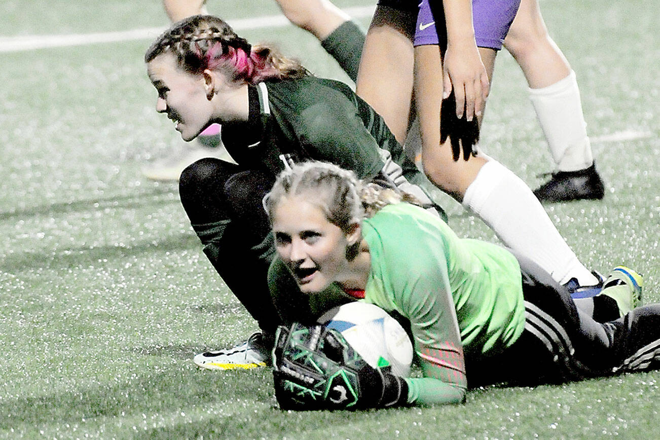 KEITH THORPE/PENINSULA DAILY NEWS
Sequim goalkeeper Kalli Grove clutched the ball after withstanding a shot by Port Angeles' Piper Alton, lower left, and is assisted by teammateAmara Gonzalez, center, on Tuesday in Port Angeles.