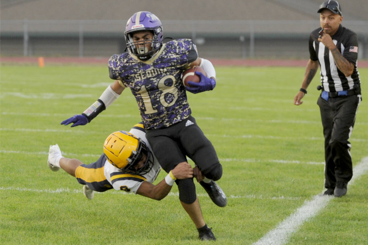 Sequim’s Malachi Hampton tries to get away from a tackle by Forks’ Bubba Hernandez in Friday’s marquee matchup between the Wolves and Spartans in Sequim. Sequim came away with a 35-26 win. (Michael Dashiell/Olympic Peninsula News Group)