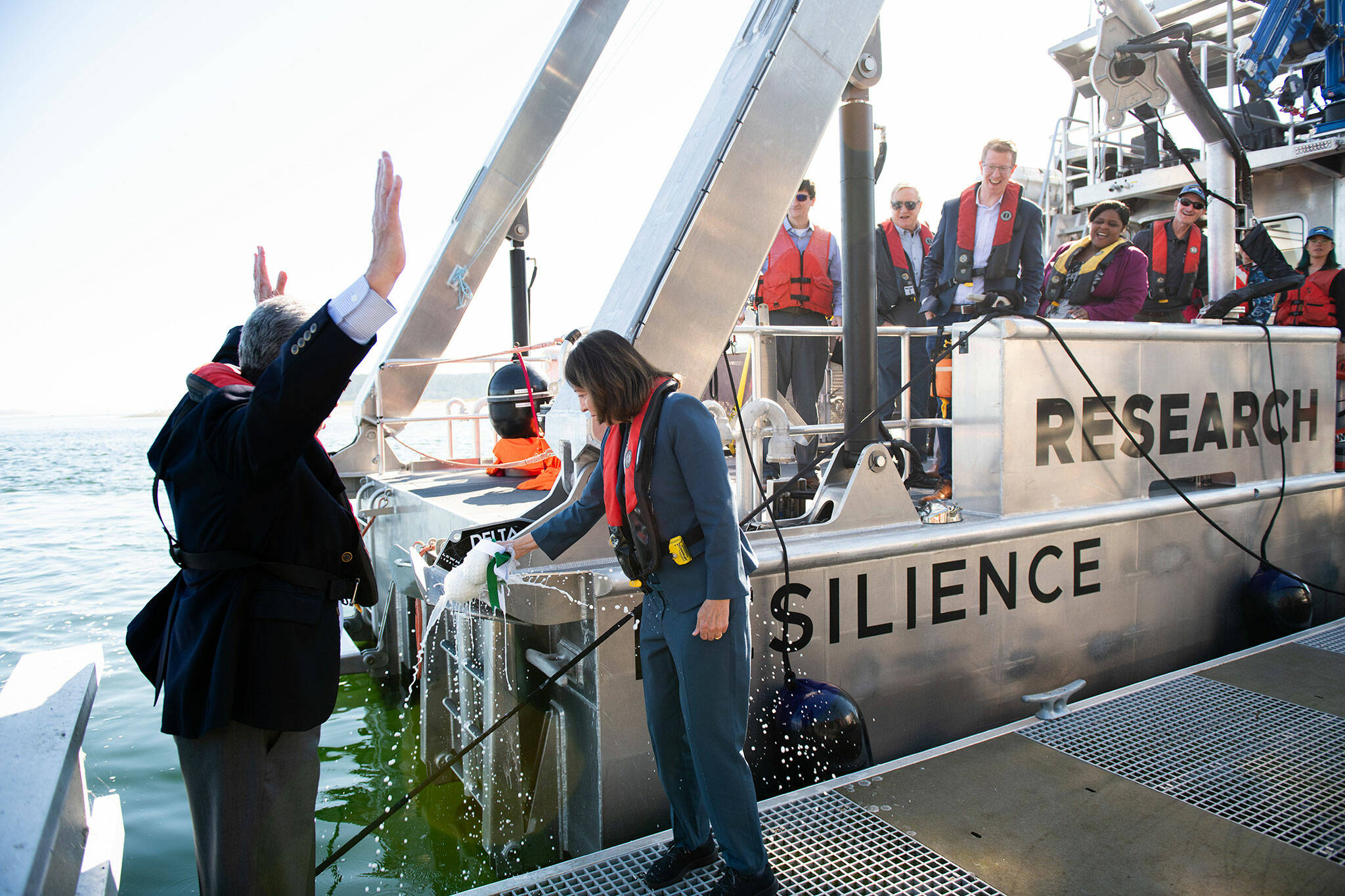 U.S. Sen. Maria Cantwell breaks a bottle of champagne over the RV Resilience on Sept. 5 as Steve Ashby, PNNL laboratory director, and other dignitaries celebrate the dedication of the hybrid vessel. (Andrea Starr/Pacific Northwest National Laboratory)