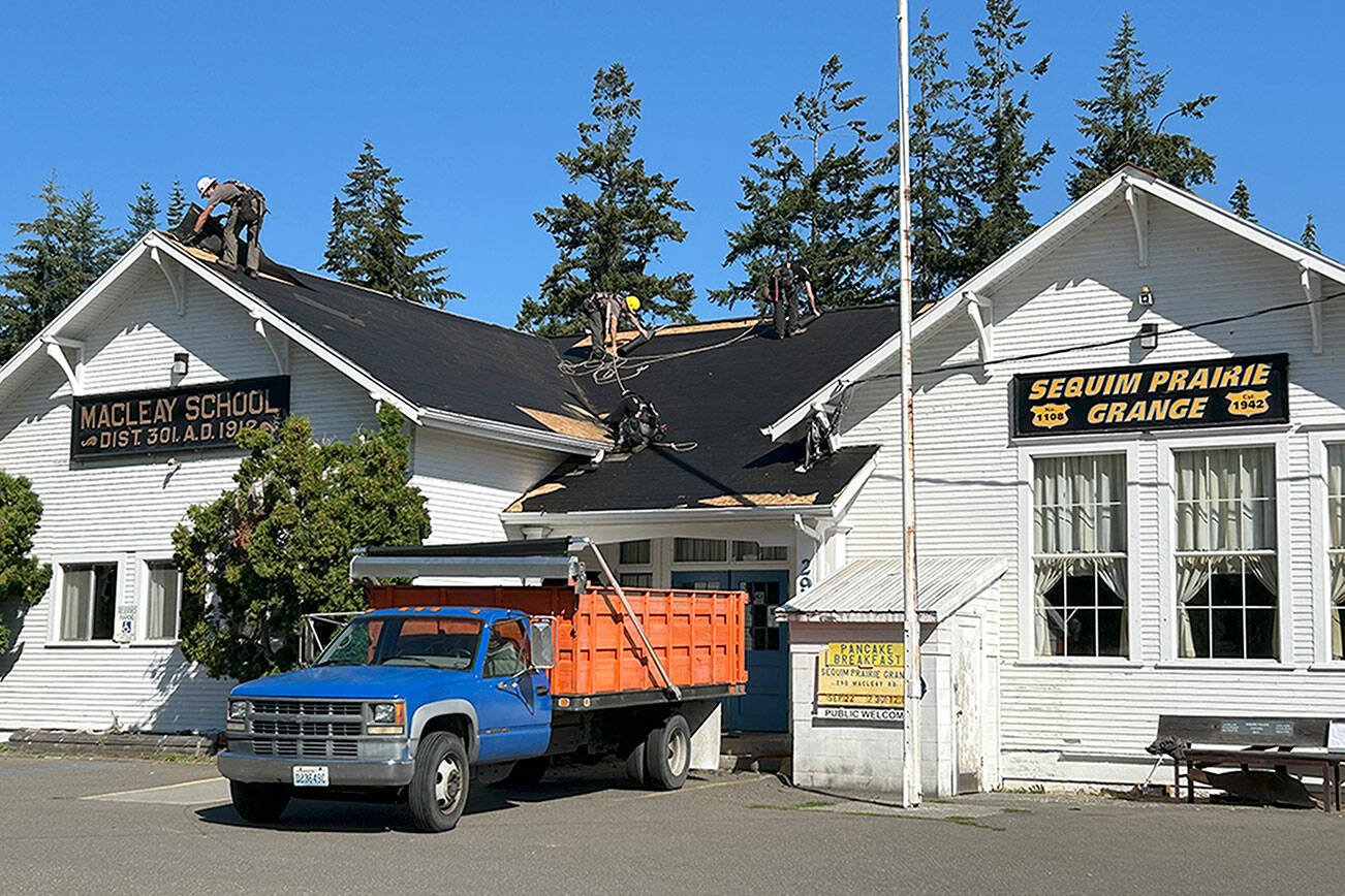 BMC Roofing crews work on Aug. 28 to replace a portion of the roof of the Sequim Prairie Grange. (Matthew Nash/Olympic Peninsula News Group)