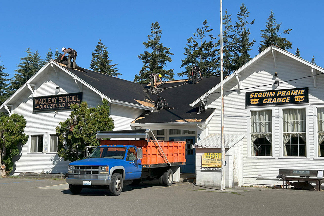 BMC Roofing crews work on Aug. 28 to replace a portion of the roof of the Sequim Prairie Grange. (Matthew Nash/Olympic Peninsula News Group)