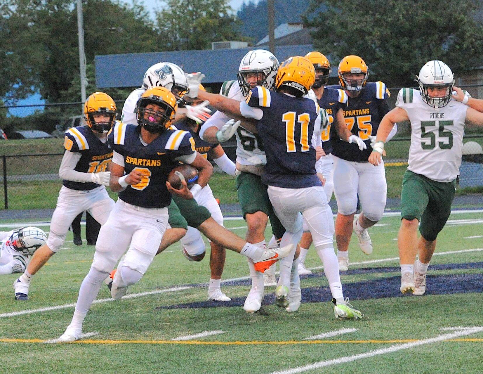 Bubba Hernandez-Stansbury somehow breaks out of a mass of tacklers and sprints for a 57-yard touchdown against Port Angeles on Friday night. Forks won a defensive battle 13-7. (Lonnie Archibald/for Peninsula Daily News)