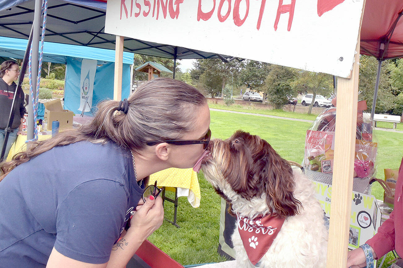 Mary Kniskern of Sonny’s Spaw and Self-Wash of Sequim gets a kiss from Winston at a “kissing booth” set up for “Music Where You Bark” for KSQM Pet Lovers Day at the James Center for the Performing Arts on Saturday in Sequim. The event featured animal-oriented display booths and live music and animal demonstrations. (Keith Thorpe/Peninsula Daily News)