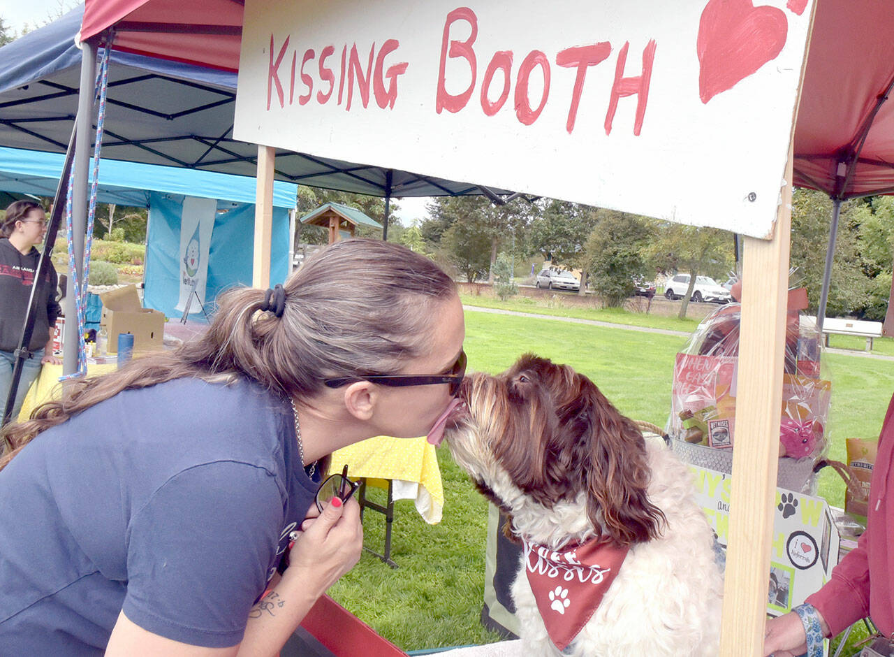 Mary Kniskern of Sonny’s Spaw and Self-Wash of Sequim gets a kiss from Winston at a “kissing booth” set up for “Music Where You Bark” for KSQM Pet Lovers Day at the James Center for the Performing Arts on Saturday in Sequim. The event featured animal-oriented display booths and live music and animal demonstrations. (Keith Thorpe/Peninsula Daily News)