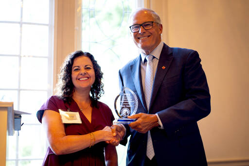 Peninsula College President Suzy Ames, left, receives the 2024 Governor’s Outstanding Leadership Award from Gov. Jay Inslee at a Sept. 10 luncheon at the Governor’s Mansion in Olympia. Ames was honored for her leadership and achievements in boosting the college’s declining enrollment and strengthening its ties to the community. (Jim Kopriva/Office of the Governor)