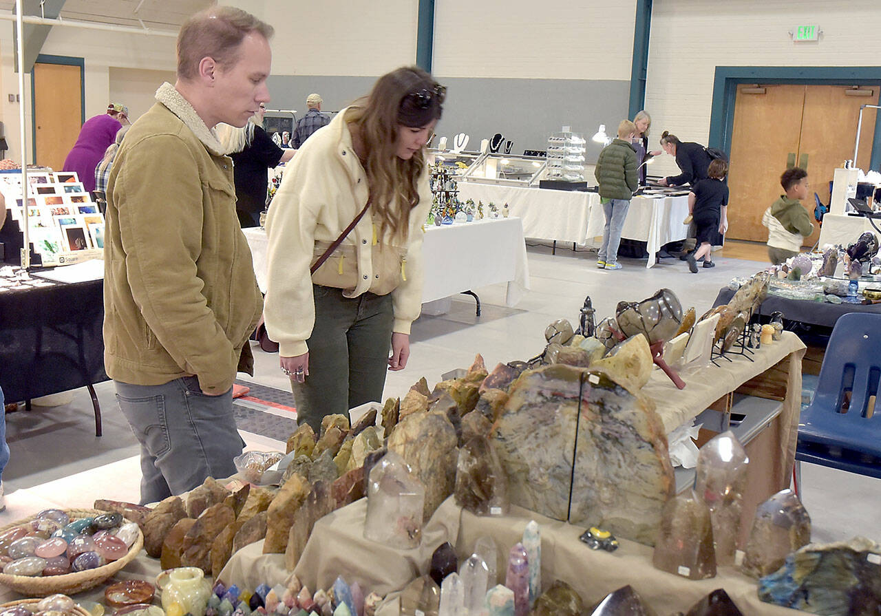 Jason Eason, left, and Amanda Krott, both of Bremerton, examine a collection of rocks and minerals on display by Rockin’ the Castle of Lebanon, Ore., during Saturday’s Gem, Rock and Jewelry Show at Vern Burton Community Center in Port Angeles. The show, hosted by the Clallam County Gem and Mineral Association, featured a wide variety of exhibits as well as an area devoted to children’s activities. (Keith Thorpe/Peninsula Daily News)