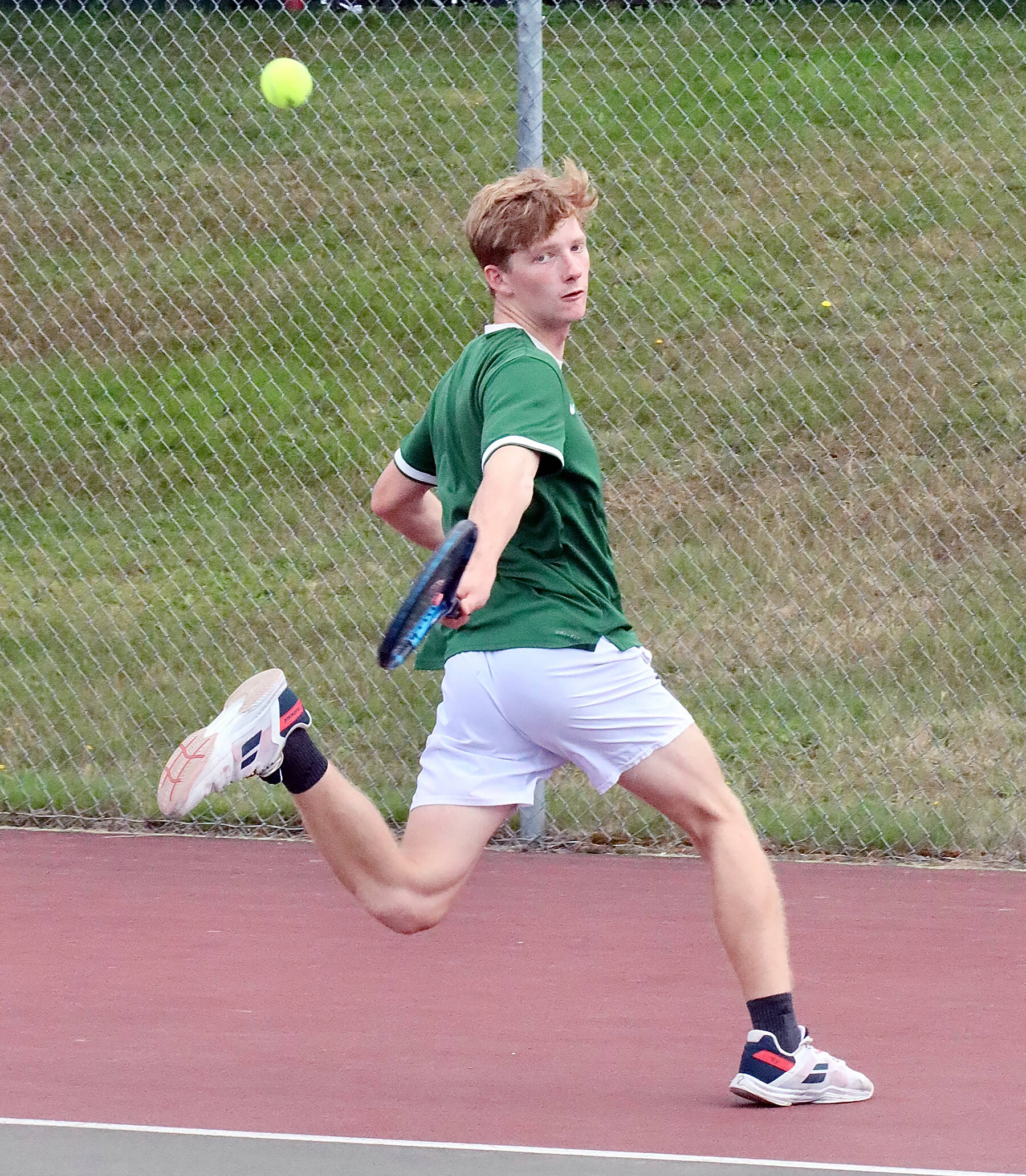 Port Angeles’ No. 1 singles player Tate Alton makes a backhand swing playing Sequim’s No. 1 Jack Crecelius on Monday in Port Angeles.