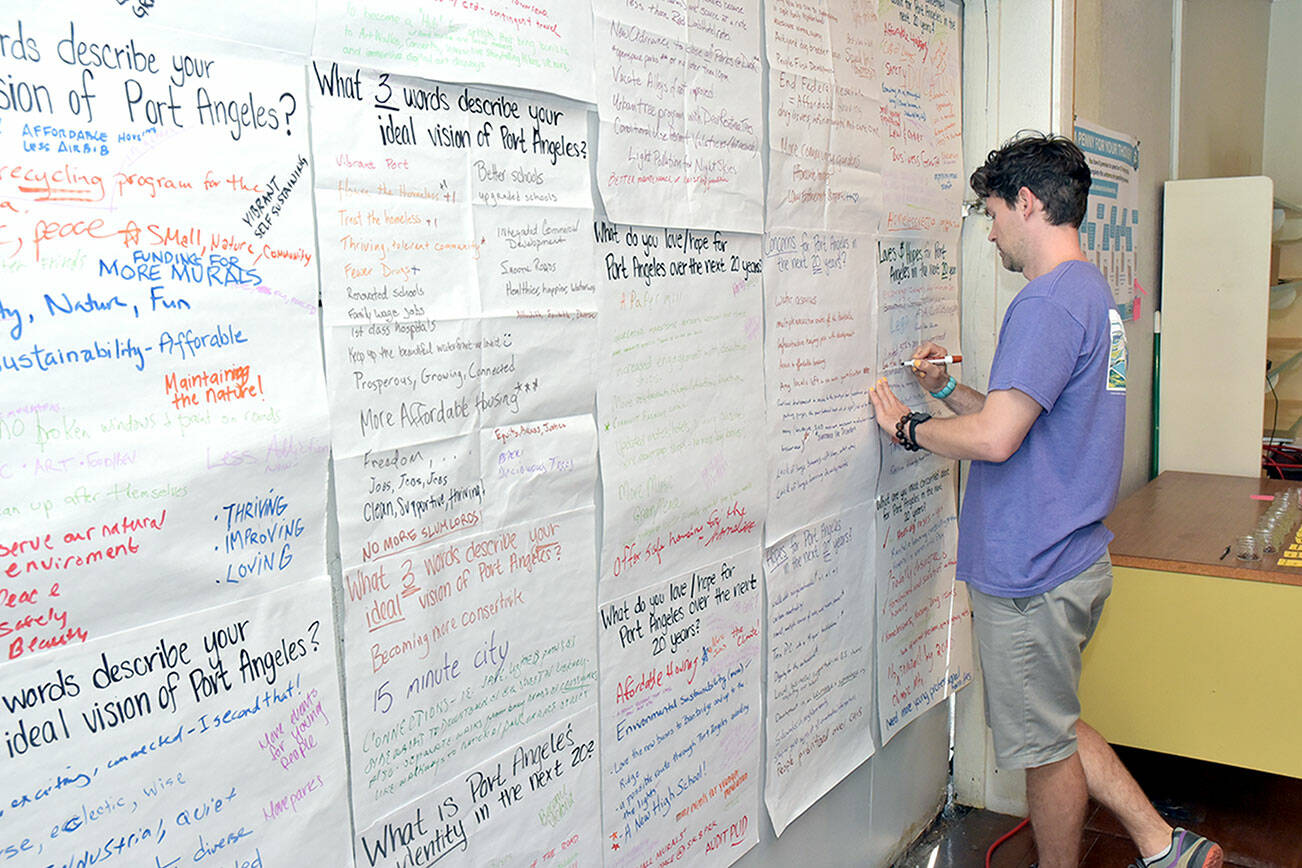 Greg Maust of Port Angeles adds his suggestions to a wall devoted to visions and suggestions for the city’s future during a Storefront Studio open house on Tuesday hosted by the city at 230 E. First St. The studio, staffed by city planners, continues today with displays and a workshop. (Keith Thorpe/Peninsula Daily News)