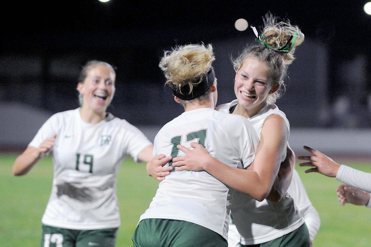 Michael Dashiell/Olympic Peninsula News Group
Port Angeles' Lilly Anne Lancaster, right, hugs teammate Ava-Anne Sheahan after scoring the game-winning goal in double overtime in the Riders' 3-2 win over rival Sequim on Thursday.