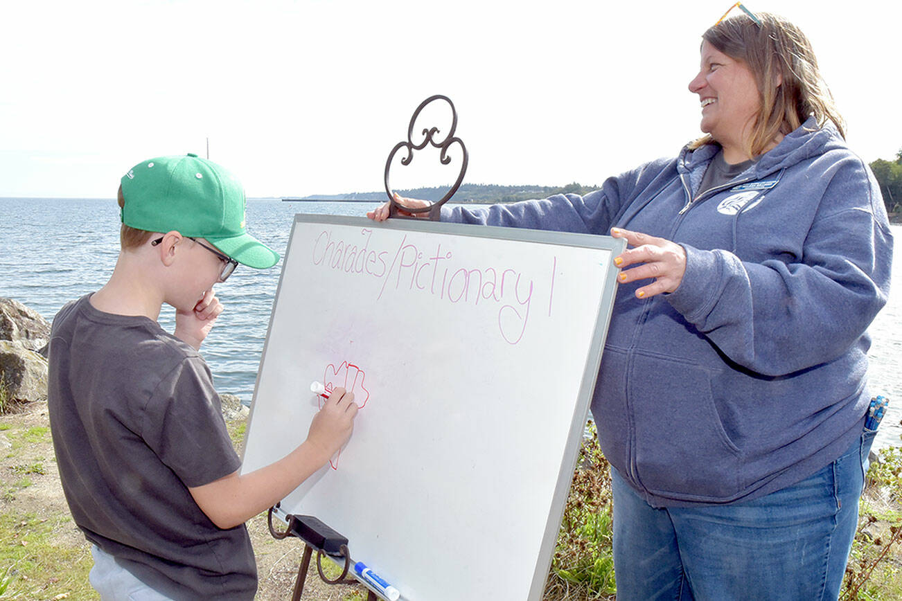 Grant Fairchild, 9, of Port Angeles plays Pictionary as Feiro Marine Life Center executive director Melissa Williams holds the drawing board outside the center on Saturday. Feiro hosted “Day of Play” with a variety of children’s activities geared toward conservation and the marine environment. (Keith Thorpe/Peninsula Daily News)