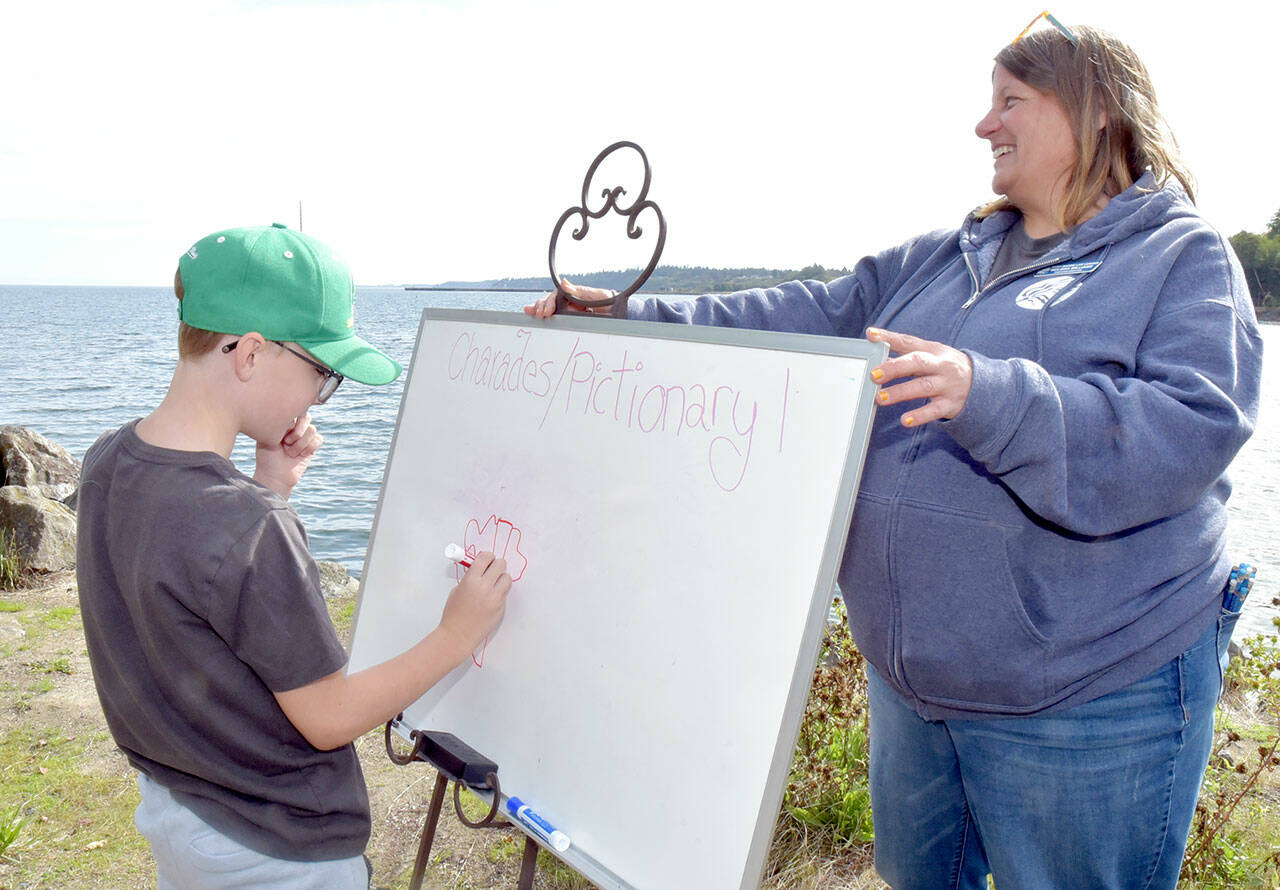 Grant Fairchild, 9, of Port Angeles plays Pictionary as Feiro Marine Life Center executive director Melissa Williams holds the drawing board outside the center on Saturday. Feiro hosted “Day of Play” with a variety of children’s activities geared toward conservation and the marine environment. (Keith Thorpe/Peninsula Daily News)