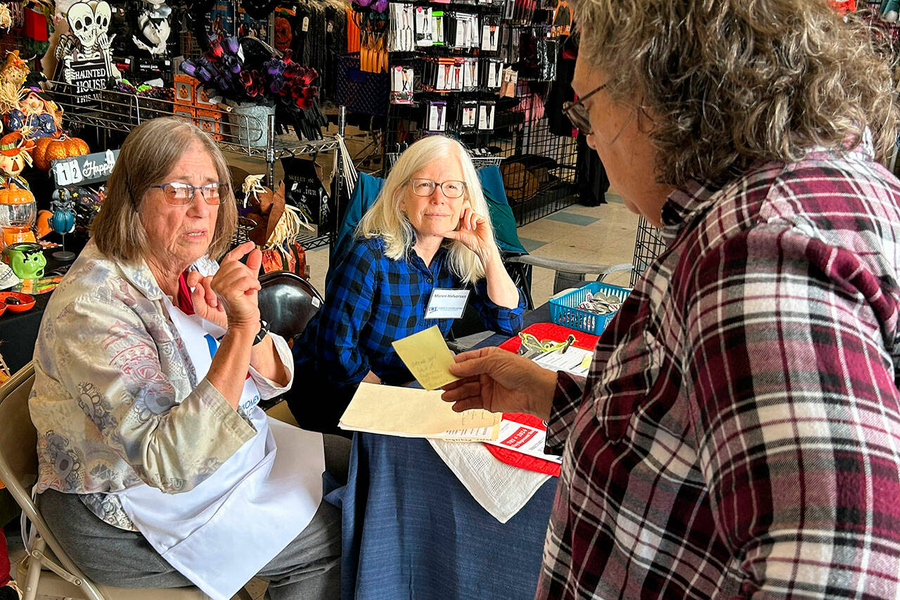 Volunteers Barbara VanderWerf and Maren Halverson, with the League of Women Voters of Clallam County, speak with a customer at Sequim Goodwill about ballot information on Sept. 17 during an information session held in conjunction with the stores in Sequim and Port Angeles on National Voter Registration Day. (Matthew Nash/Olympic Peninsula News Group)