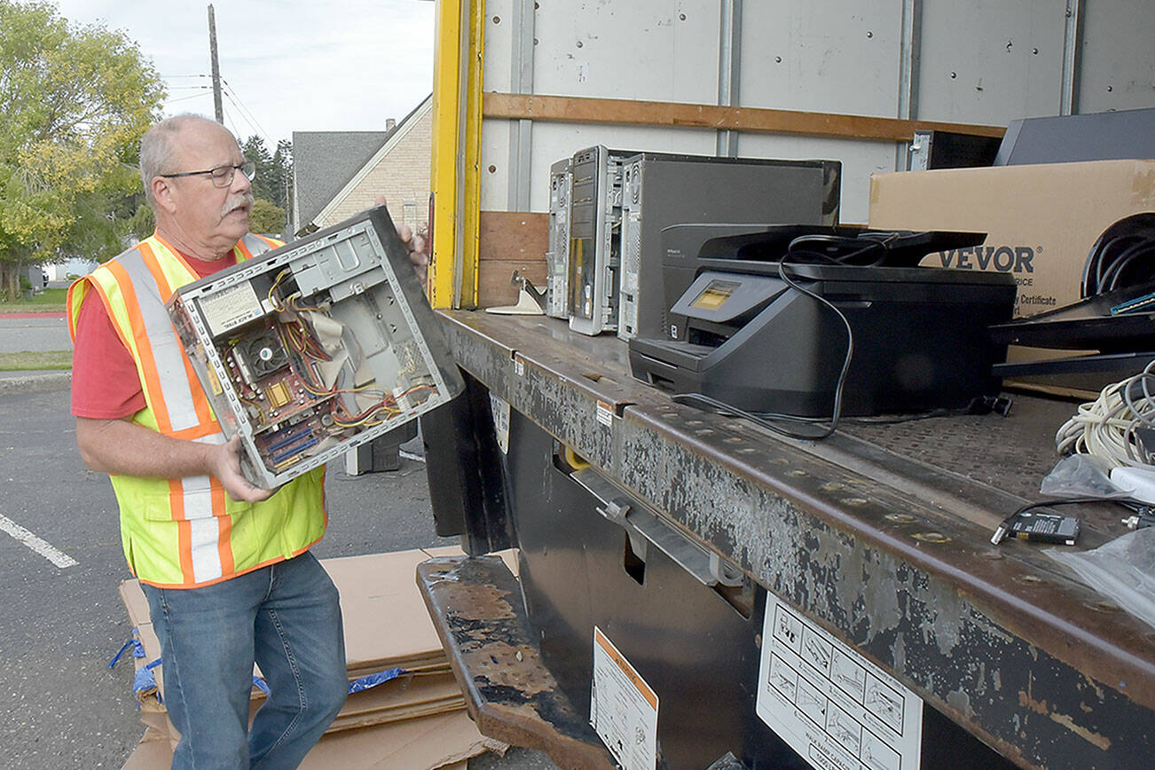 Olympic Kiwanis Club member Tom Clark of Joyce loads a discarded computer onto a truck for recycling during Saturday’s e-Waste Recycling Day at in the parking lot at Port Angeles Civic Field. The club took in stacks of used computers, television sets, printers and other home electronics with donations going to the club’s children’s programs. (Keith Thorpe/Peninsula Daily News)