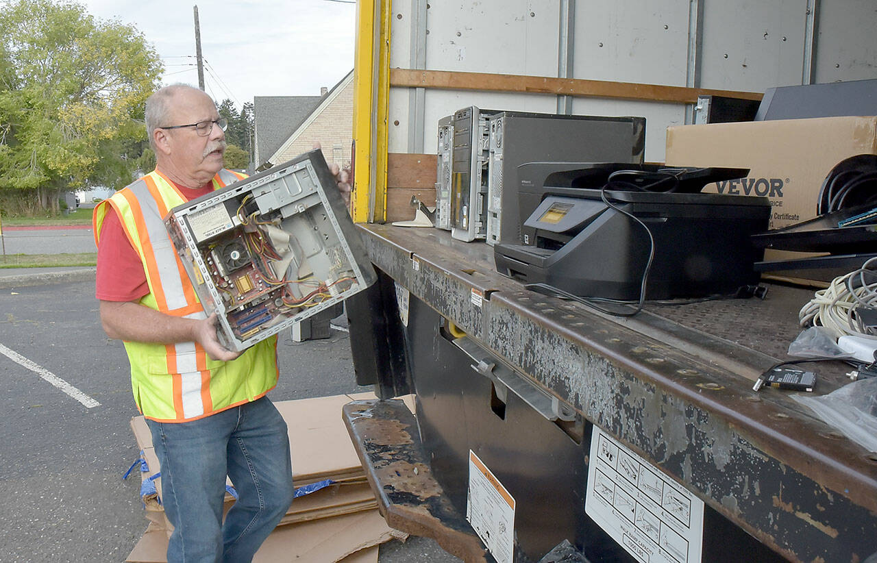 Olympic Kiwanis Club member Tom Clark of Joyce loads a discarded computer onto a truck for recycling during Saturday’s e-Waste Recycling Day at in the parking lot at Port Angeles Civic Field. The club took in stacks of used computers, television sets, printers and other home electronics with donations going to the club’s children’s programs. (Keith Thorpe/Peninsula Daily News)