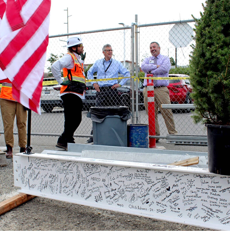 Jefferson Healthcare CEO Mike Glenn and COO Jacob Davidson observe as the top steel member is prepared to be installed on the new building. (Jefferson Healthcare)