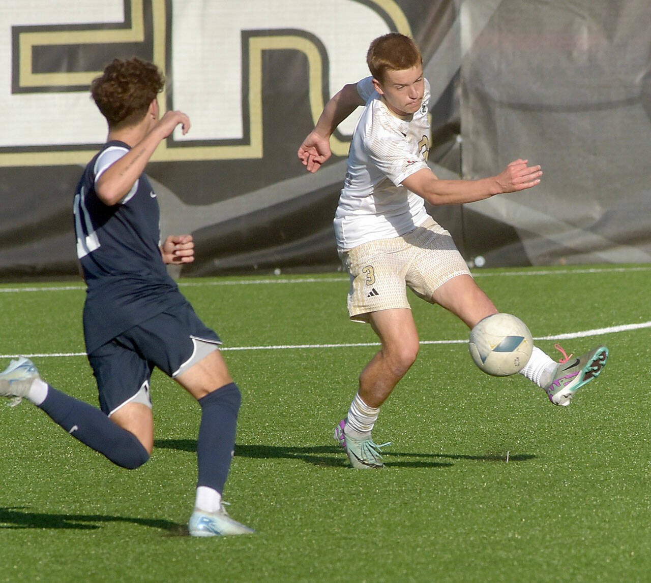 KEITH THORPE/PENINSULA DAILY NEWS Peninsula’s Caleb Rollo, right, passes around the defense of Bellevue’s Derek Johnson on Wednesday at Wally Sigmar Field in Port Angeles.