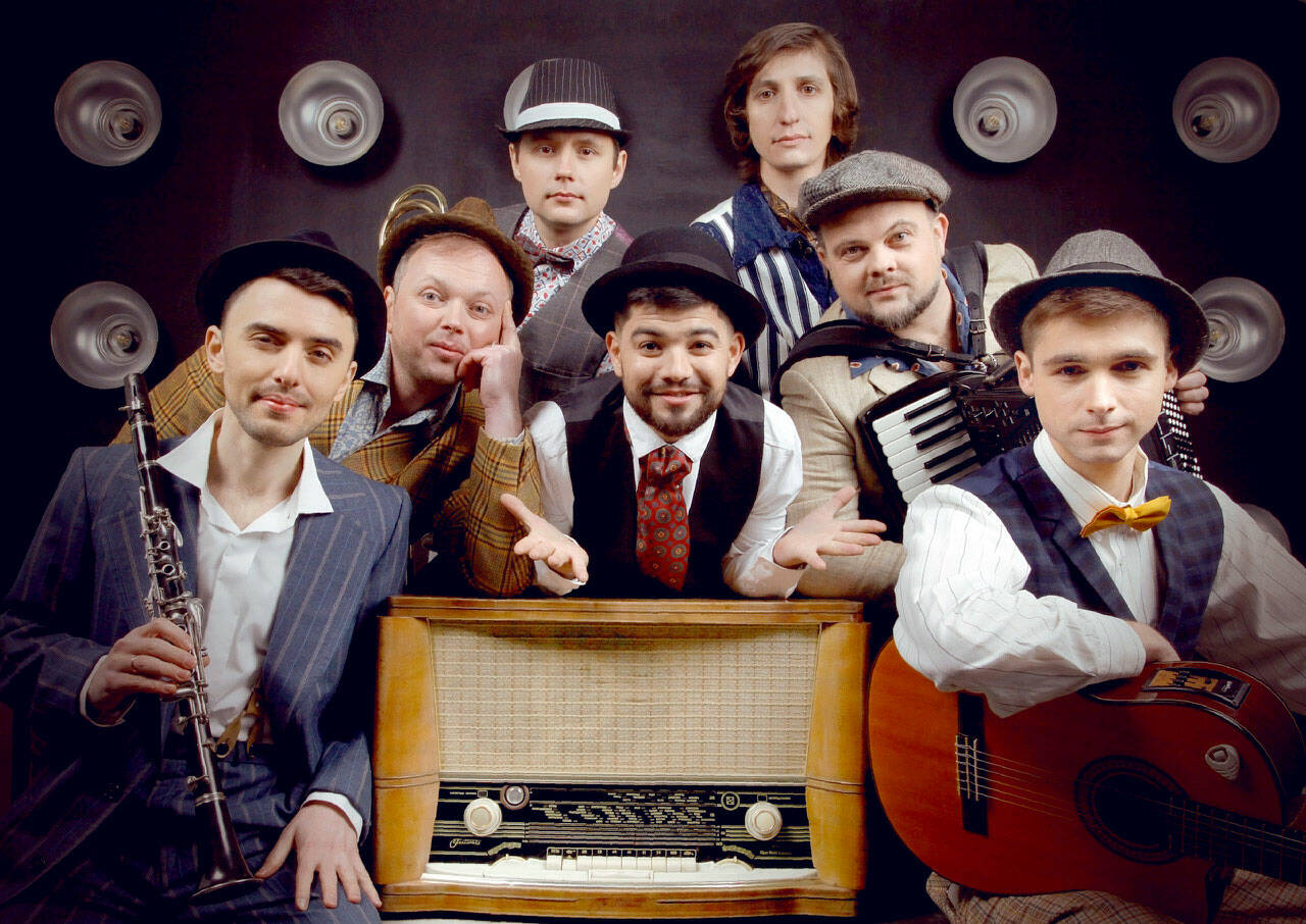 Bagrat Tsurkan (vocals) in center. Clockwise from the bottom left, Volodymyr Gitin (clarinet), Andrei Okhramovich (trumpet), Yaroslav Besh (trombone), Sergei Poltorak (percussion), Oleg Vasianovich (accordion) and Viktor Kirilov (acoustic guitar).