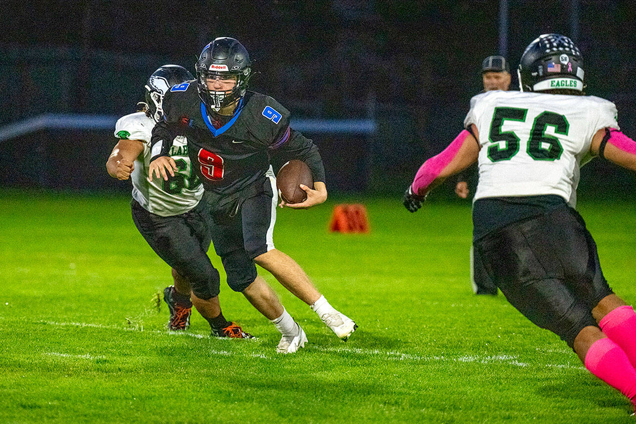 Steve Mullensky/for Peninsula Daily News

Rivals' quarterback Silas Morford spots a hole and runs for yardage in a Nisqually League game played against the Klahowya Eagles on Friday night at Memorial Field in Port Townsend.