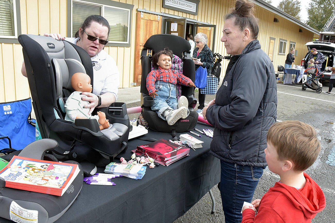 Laurie Hutchings of Port Angeles, right, and her grandson, Regan Davis, 5, of Port Angeles examine a display of infant car seats as Crystal Clark, a volunteer car seat technician for the Sequim Police Department, describes their function during Saturday’s Public Safety Fair at the Guy Cole Convention Center at Carrie Blake Park in Sequim. The event featured a variety of public safety agencies and their equipment, as well as lectures and other presentations. (Keith Thorpe/Peninsula Daily News)