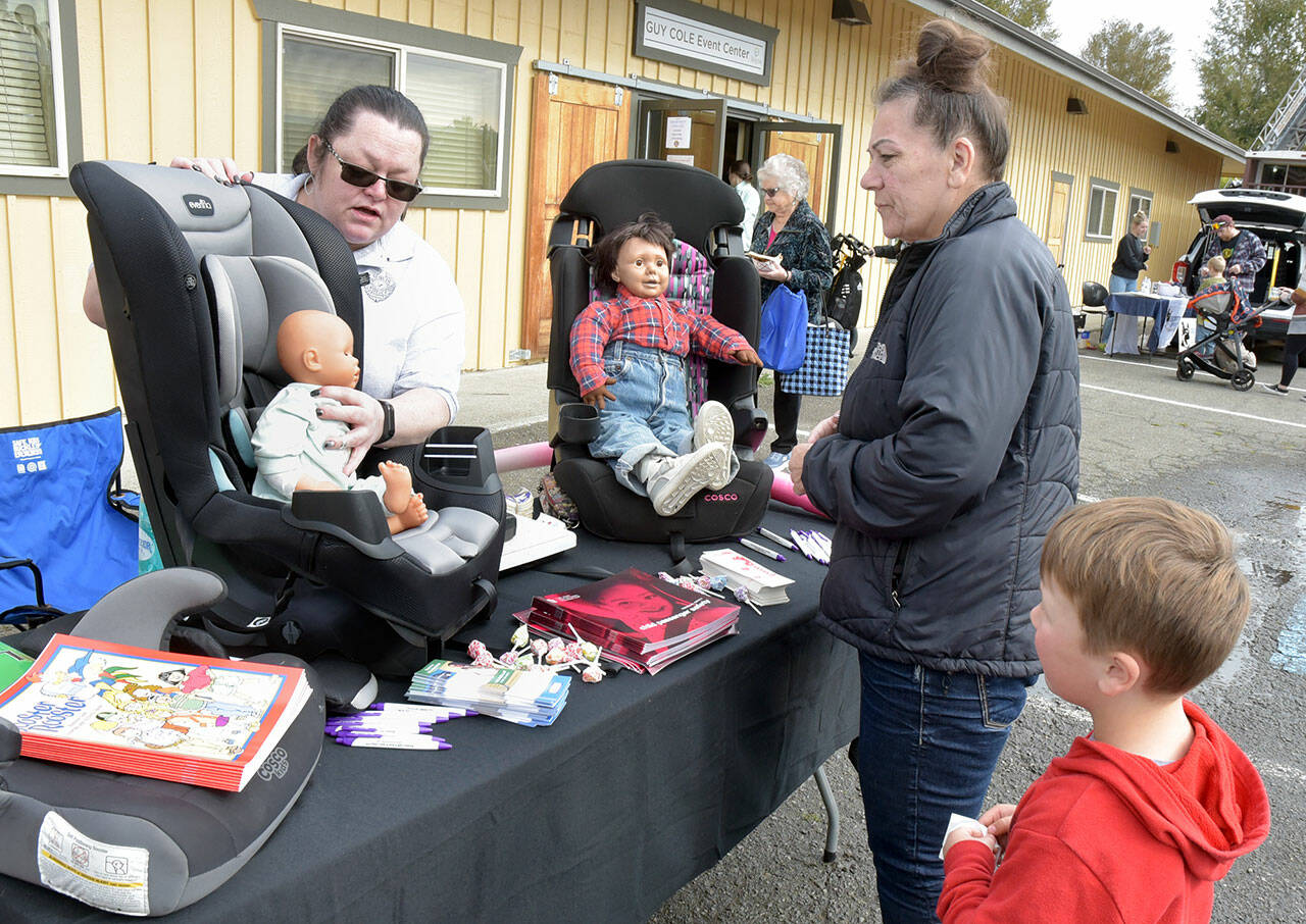 Laurie Hutchings of Port Angeles, right, and her grandson, Regan Davis, 5, of Port Angeles examine a display of infant car seats as Crystal Clark, a volunteer car seat technician for the Sequim Police Department, describes their function during Saturday’s Public Safety Fair at the Guy Cole Convention Center at Carrie Blake Park in Sequim. The event featured a variety of public safety agencies and their equipment, as well as lectures and other presentations. (Keith Thorpe/Peninsula Daily News)