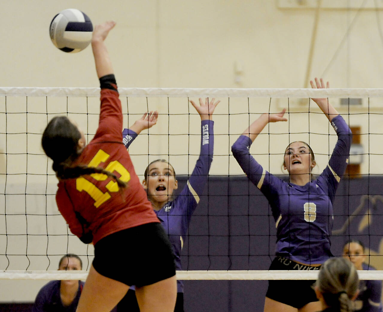 Sequim’s Sydney Clark, left, and Rose Gibson rise up to block a kill attempt from Kingston’s Maddie Brown (15). Sequim won 3-0 to remain near the top of the Olympic League standings. (Michael Dashiell/for Peninsula Daily News)