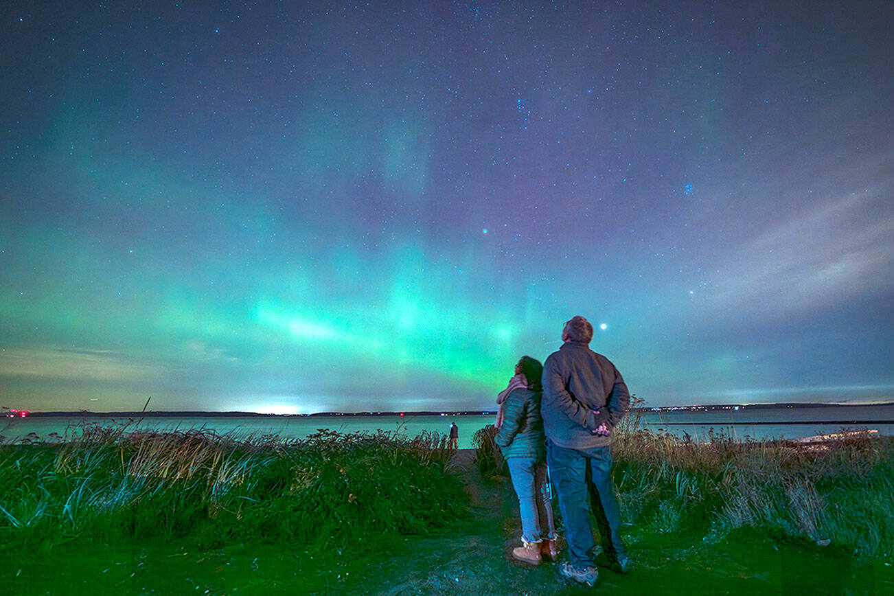 Steve Mullensky/for Peninsula Daily News

Joel Goldstein and wife Len Maranan-Goldsmith, from Port Townsend, take in the Aurora Borealis Thursday night from the beach at Point Hudson in Port Townsend.