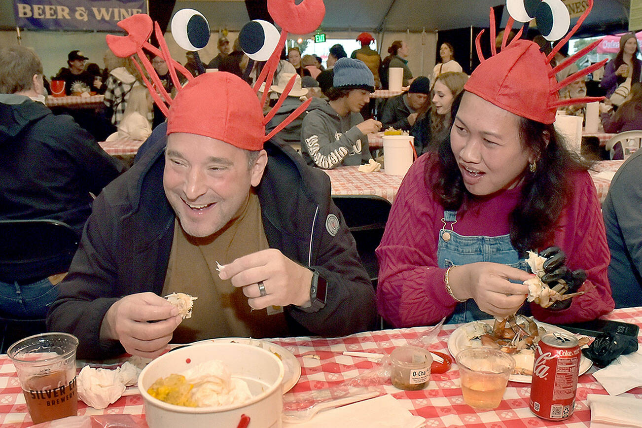 David and Tor Patsiga of University Place enjoy a crab dinner on Saturday during the annual Dungeness Crab Festival in downtown Port Angeles. The three-day event featured a variety of seafoods and other culinary treats, as well as crafts, music and other activities. (Keith Thorpe/Peninsula Daily News)