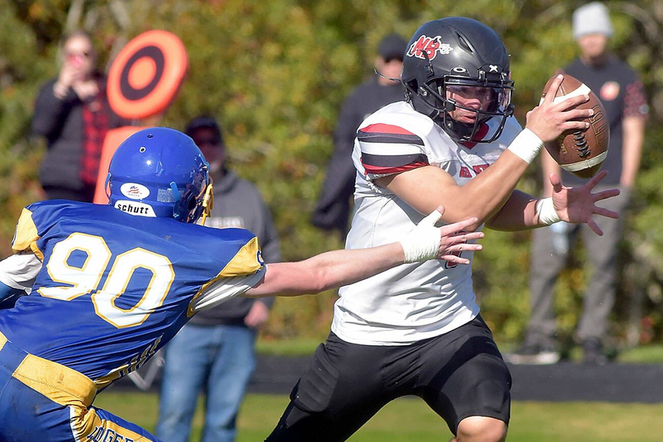 Neah Bay running back Jodell Wimberly evades the tackle of Crescent’s Logan Simons during Saturday’s game in Joyce. (Keith Thorpe/Peninsula Daily News)