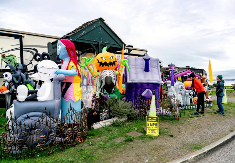 Lori Bernstein, left, and Lindy Brooking, both from Port Townsend, pause from their morning walk to look at the Halloween display set up by the Point Hudson RV Park host. (Steve Mullensky/for Peninsula Daily News)