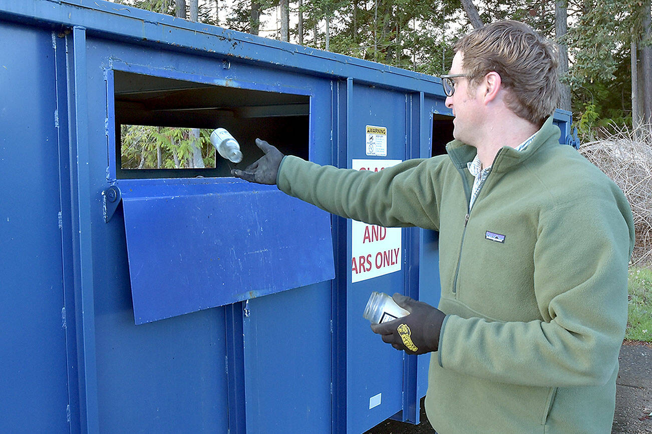 Beeler Van Orman of Port Angeles tosses a glass bottle into a recycling bin on Thursday at the Regional Transfer Station in Port Angeles. (Keith Thorpe/Peninsula Daily News)