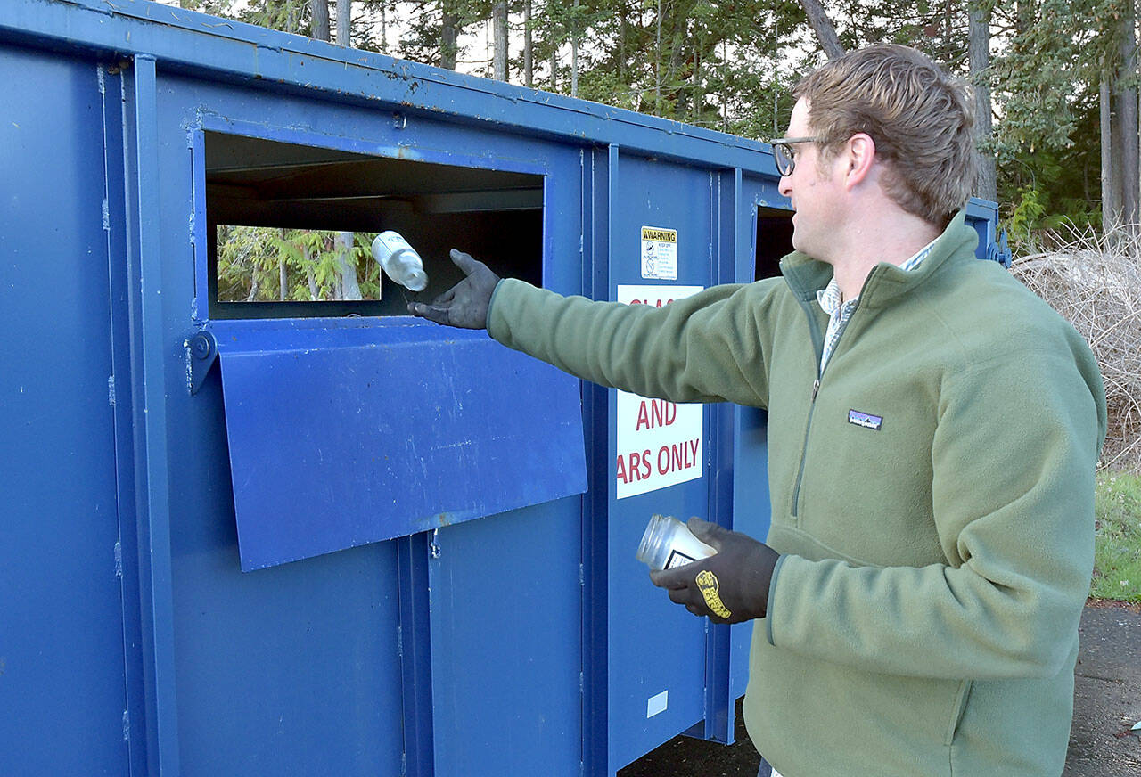 Beeler Van Orman of Port Angeles tosses a glass bottle into a recycling bin on Thursday at the Regional Transfer Station in Port Angeles. (Keith Thorpe/Peninsula Daily News)