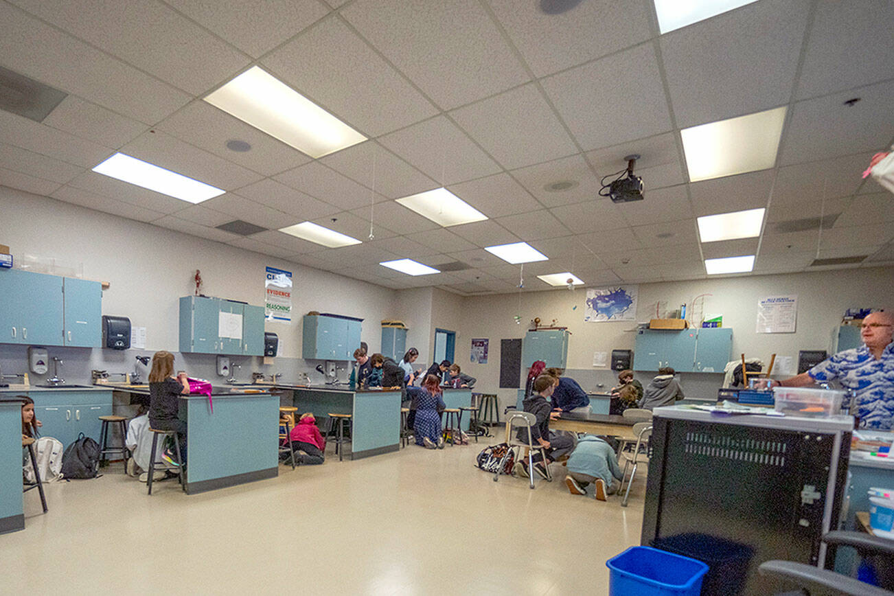 Students in Niall Twomey’s seventh-grade science class take cover under their workstations during a Great Shakeout drill on Thursday at Blue Heron Middle School in Port Townsend. The students dropped, took cover and held on for the duration of the 30-second drill in order to build muscle memory in the event of a real earthquake or tsunami on the Peninsula. (Steve Mullensky/for Peninsula Daily News)